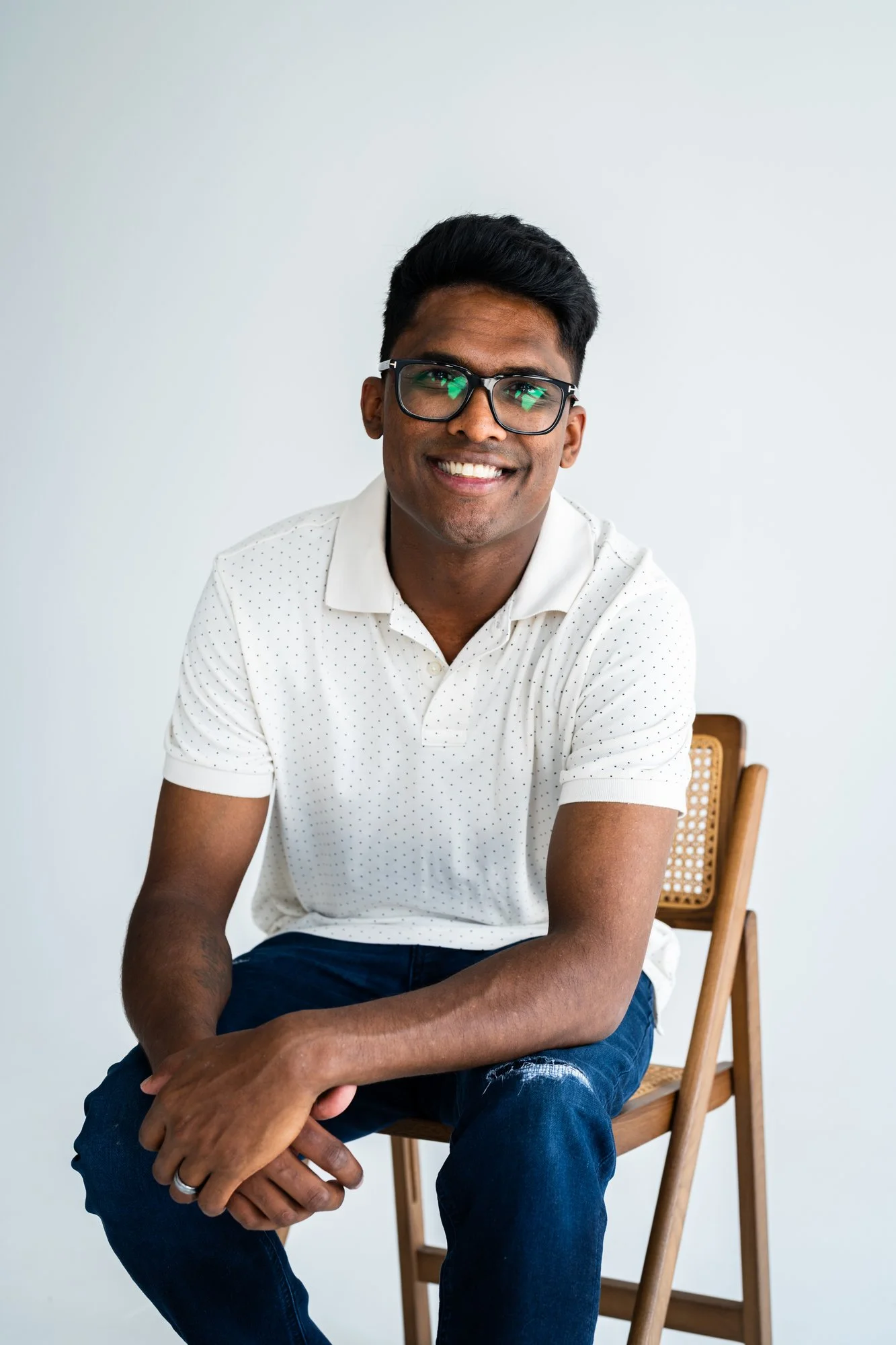 Suthan, seated and smiling